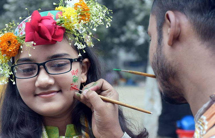 গালে বিজয়ের আলপনা আঁকাচ্ছে এক কিশোরী। ছবি : বিপ্লব দিক্ষিৎ